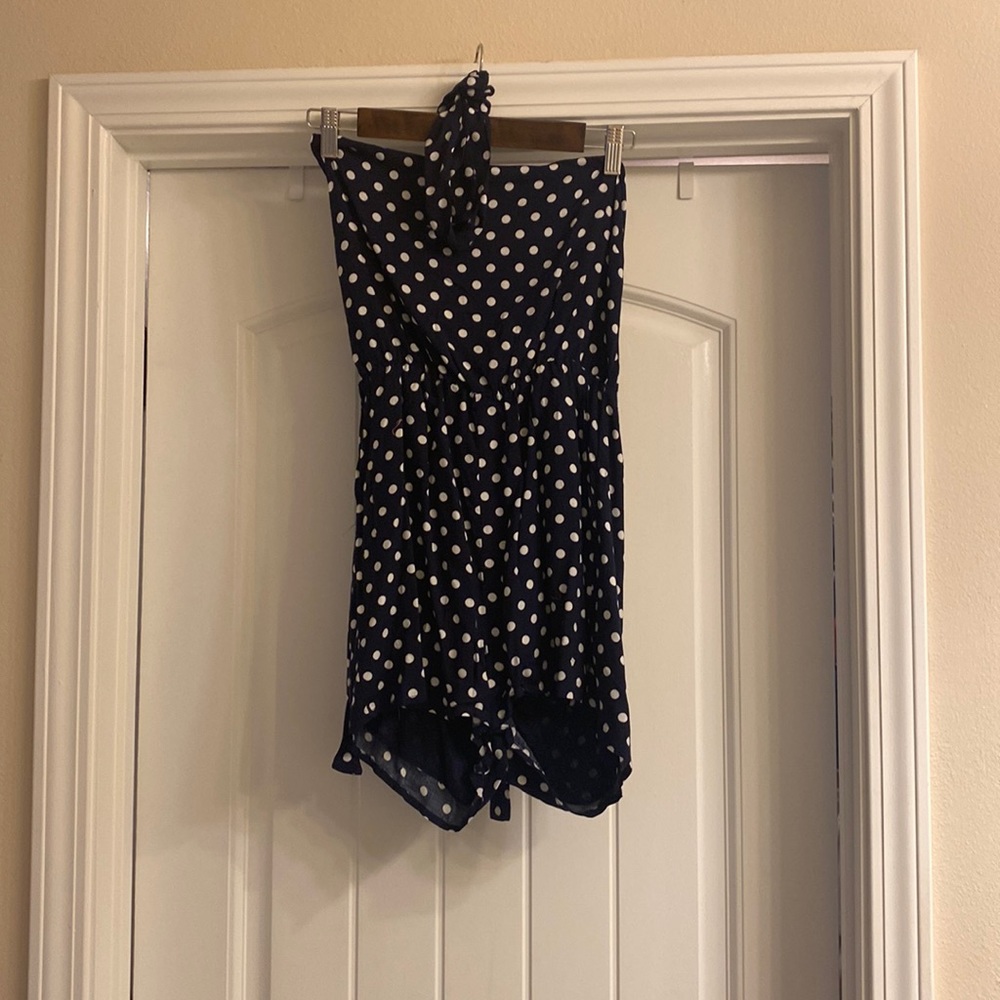 Navy and white polka dot halter top romper with strap to tie around waist.